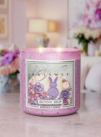 Kringle Candle Easter-themed candle on a table with blurred floral background