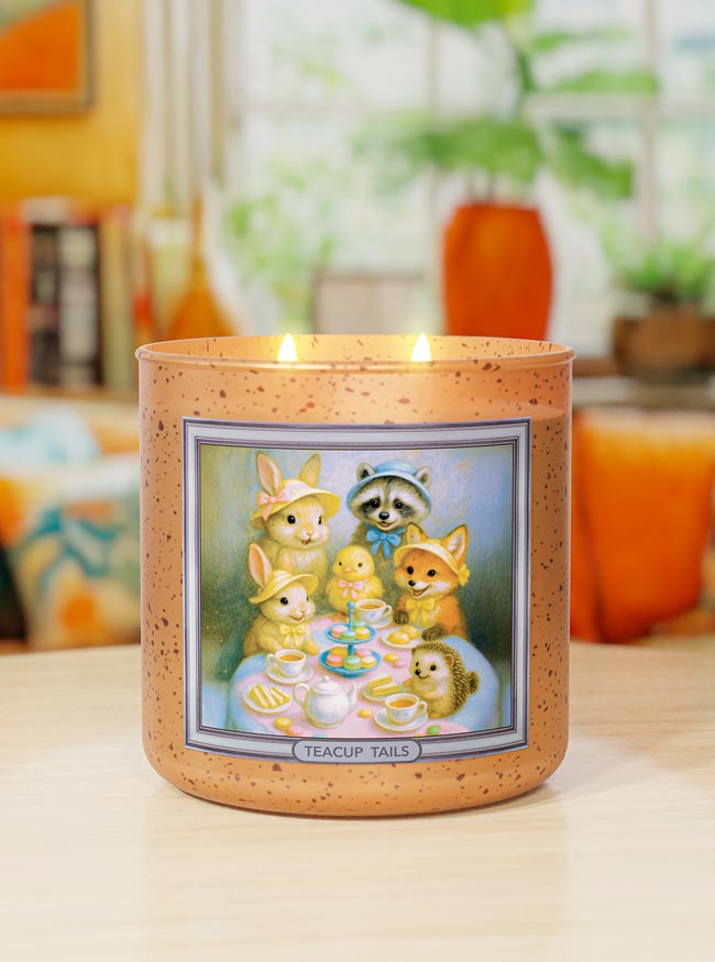 Candle with a decorative label featuring cartoon characters on a table.