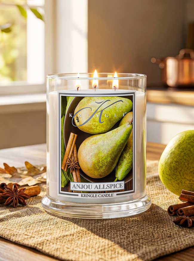 Kringle Candle labeled 'Anjou Allspice' with pears and cinnamon sticks on a table.