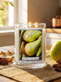 Kringle Candle labeled 'Anjou Allspice' with pears and cinnamon sticks on a table.