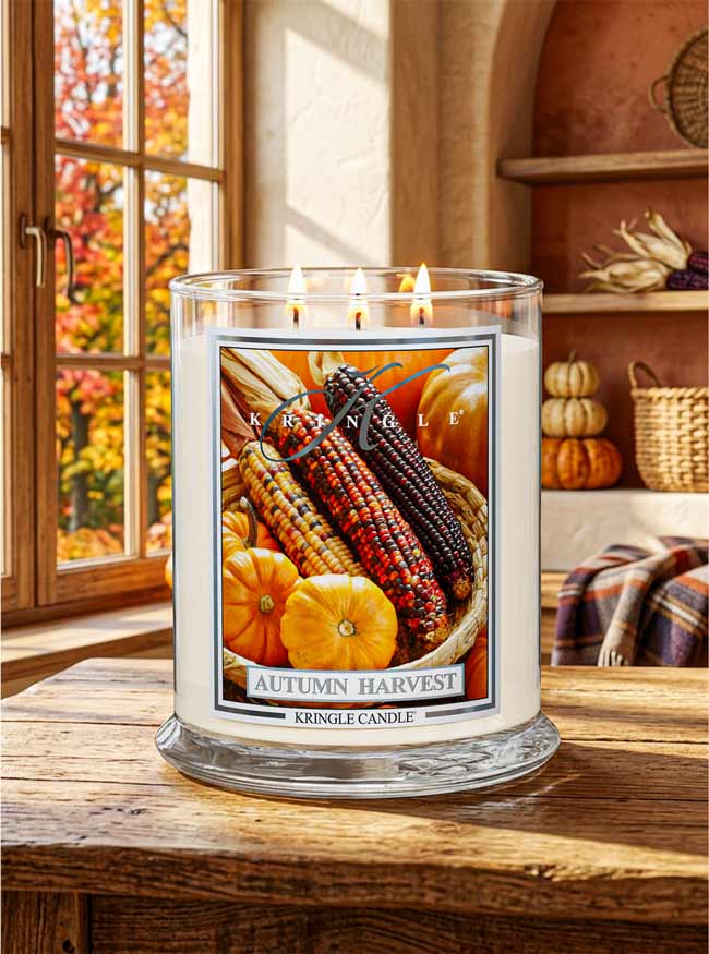 Autumn Harvest Kringle Candle on a wood table with corn and pumpkins on label and a fall décor kitchen interior