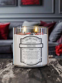 Healing Light Lit Scented Candle with a label on a surface, with a blurred background of a room.