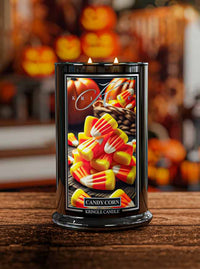 Kringle Candle with candy corn design on a wooden surface with Halloween-themed background