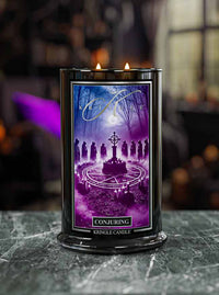 Kringle Candle 'Conjuring' candle with a purple label featuring silhouettes and a cross on a dark background.