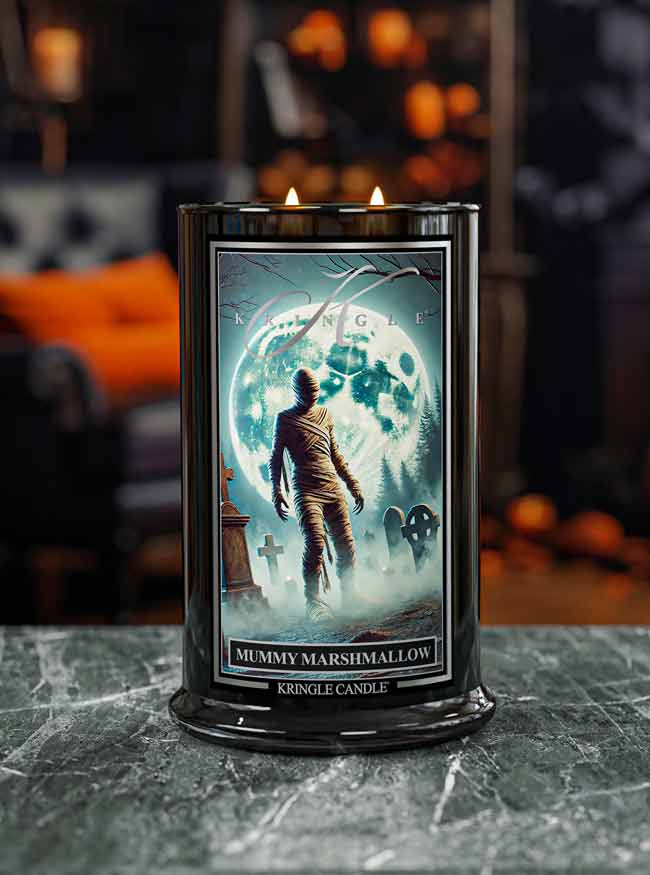 Kringle Candle mummy marshmallow candle with a Halloween-themed label on a dark surface.