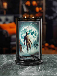 Kringle Candle mummy marshmallow candle with a Halloween-themed label on a dark surface.
