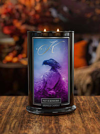 Kringle Candle with a purple label featuring a bird design on a wooden surface.