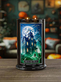 Kringle Candle Halloween-themed candle with a haunted house design on a wooden surface.