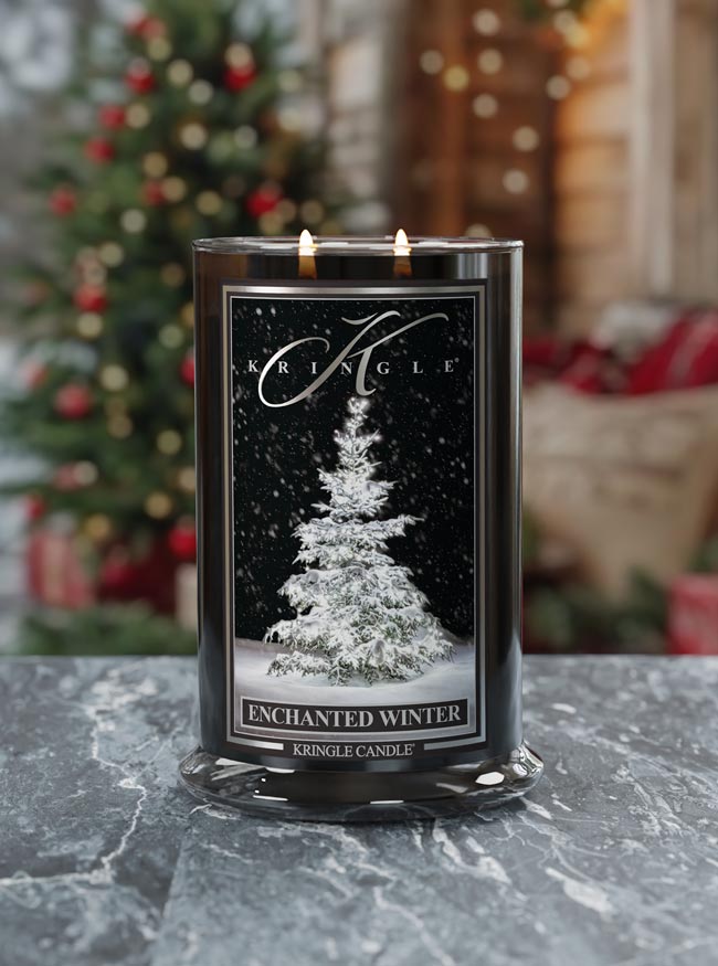 Kringle Candle with 'Enchanted Winter' label in front of a decorated Christmas tree.