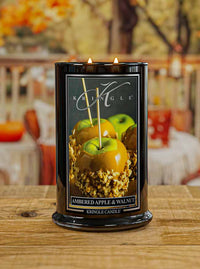 Kringle Candle with 'Ambered Apple & Walnut' fragrance on a wooden surface.