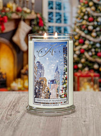 Kringle Candle with Christmas in Manhattan design in front of a decorated Christmas tree and fireplace.