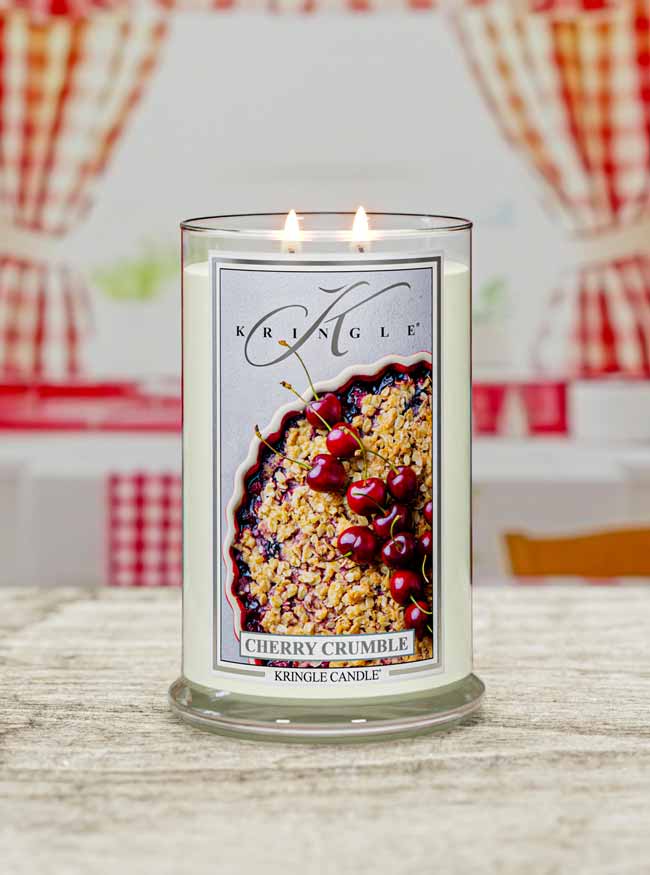 Kringle Candle cherry crumble scented candle on a table with a plaid background
