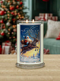 Kringle Candle with Santa and reindeer design in front of a Christmas tree and presents.