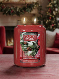 Country Candle Christmas Wreath candle on a table with a festive background