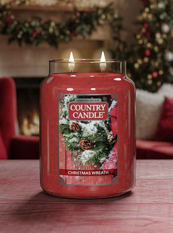 Country Candle Christmas Wreath candle on a table with a festive background