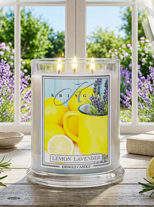 Kringle Candle Lemon Lavender candle on a windowsill with a view of greenery outside.