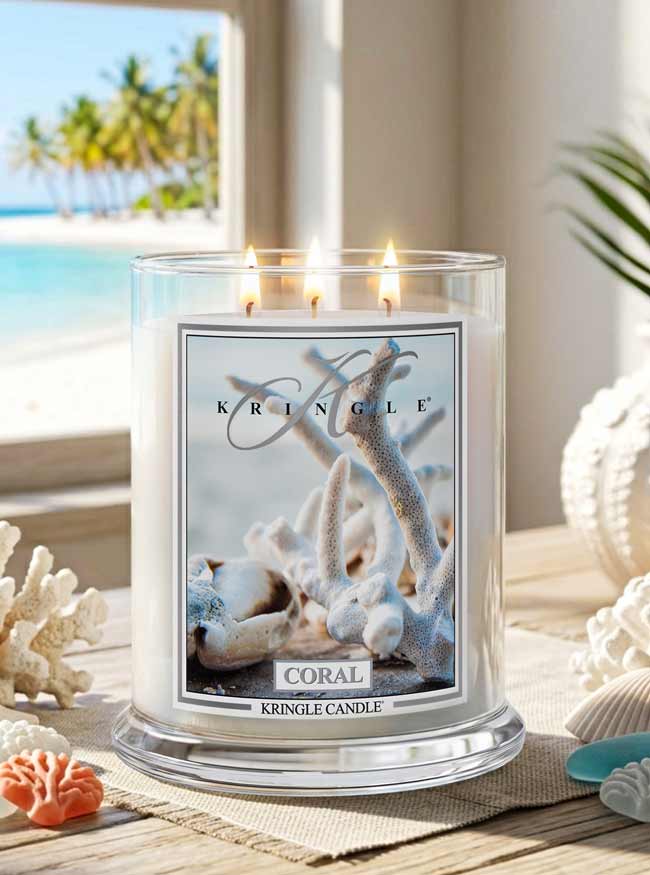 Kringle Candle in Coral scent on a table with beach decor