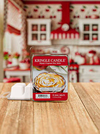 Kringle Candle Apple Cider Cake wax melt packaging on a wooden surface with a blurred kitchen background.