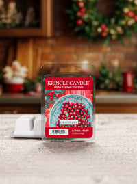 A package of Kringle Candle Granmary highly fragrant wax melts stands on a light textured surface with its white plastic clamshell tray partially visible behind it. The product packaging features a red label with an illustration of red cranberries in a blue bowl.