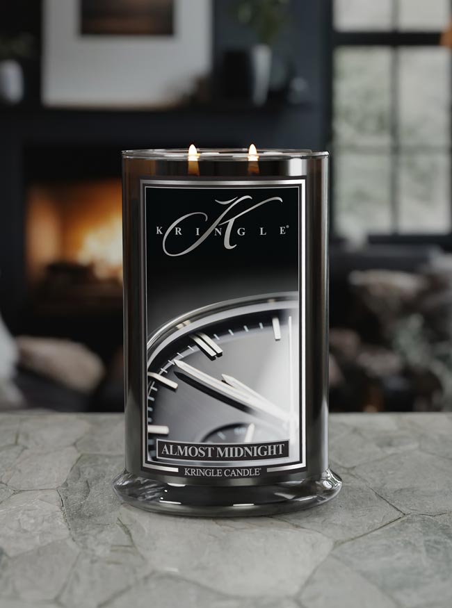Kringle Candle labeled 'Almost Midnight' on a stone surface with a blurred indoor background
