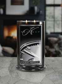 Kringle Candle labeled 'Almost Midnight' on a stone surface with a blurred indoor background