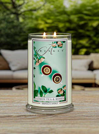 Kringle Candle labeled 'Lemon Tea & Roses' on a wooden surface with a blurred outdoor background.