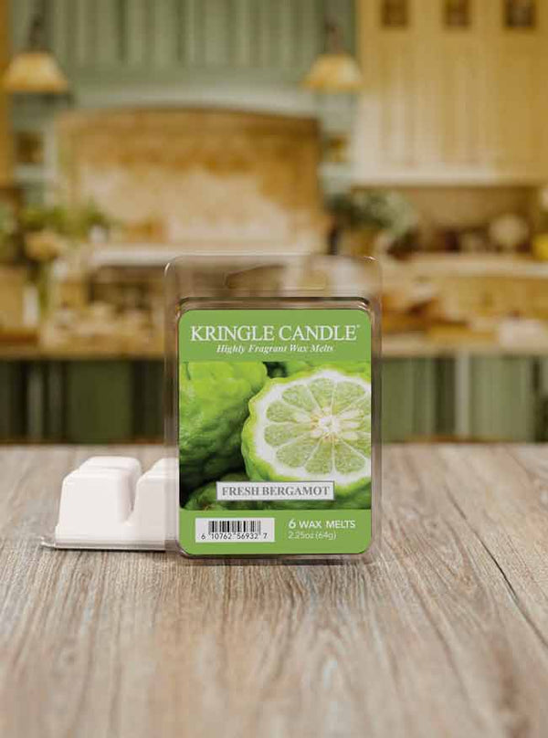 Kringle Candle Fresh Bergamot wax melts packaging on a wooden surface with a blurred kitchen background.