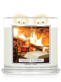 Lit Whiskey & Embers XL 4-Wick candle; label shows fireplace with a whiskey glass and an open book nearby.