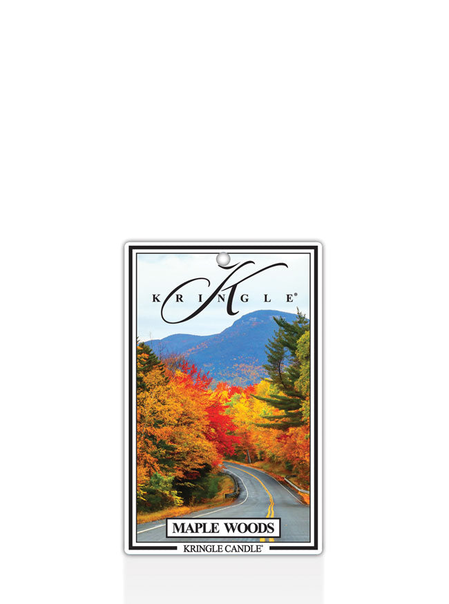 Kringle Candle Maple Woods air freshener with a scenic design of a road flanked by trees with autumn foliage.