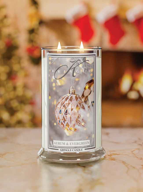 Kringle Candle with decorative label on a marble surface with Christmas stockings in the background