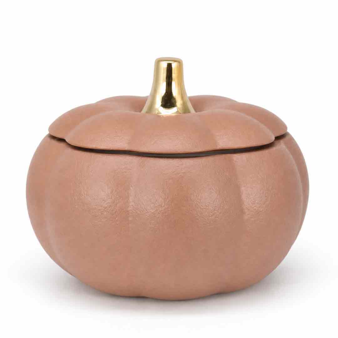 A small pumpkin-shaped container with a textured matte finish in a warm tan-brown color, featuring a shiny gold metallic stem on the lid, set against a plain white background.