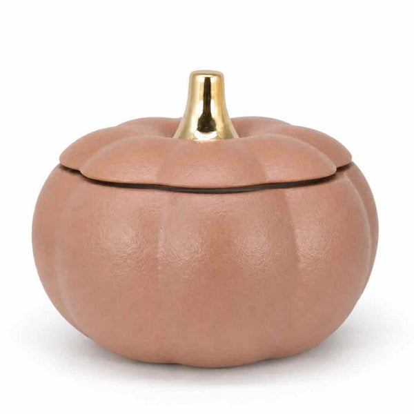 A small pumpkin-shaped container with a textured matte finish in a warm tan-brown color, featuring a shiny gold metallic stem on the lid, set against a plain white background.