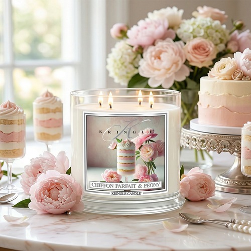 Kringle Candle with floral design on a table with flowers and cake