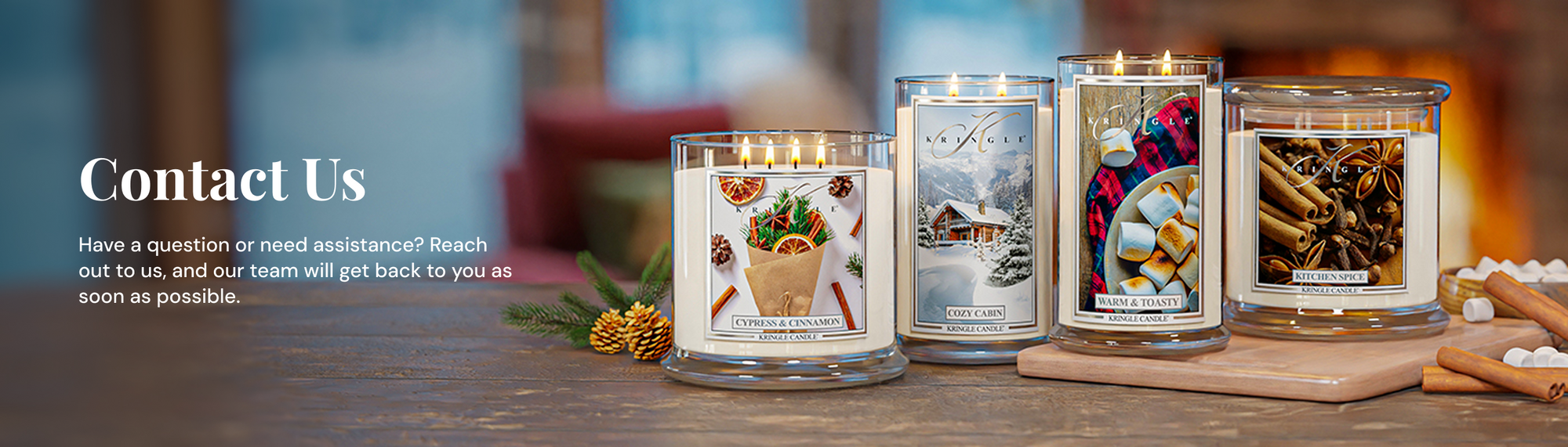 Four candles with decorative labels on a wooden surface, with text about contact information.