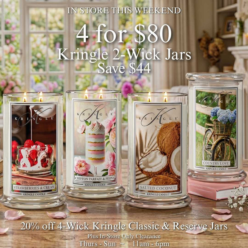Four lit Kringle Candle 2-Wick jars on a wood table, 4 for $80 this weekend, save $44, in store Thursday through Sunday.