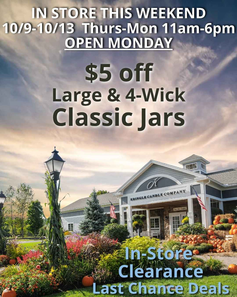 A scenic view of the Kringle Candle store in Bernardston, Massachusetts, surrounded by colorful fall flowers and pumpkins under a cloudy autumn sky. Text on the image announces an in-store promotion: "$5 off Large & 4-Wick Classic Jars" and highlights "In-Store Clearance Last Chance Deals," with the event running Thursday through MONDAY, October 9–12, from 11 AM to 6 PM.