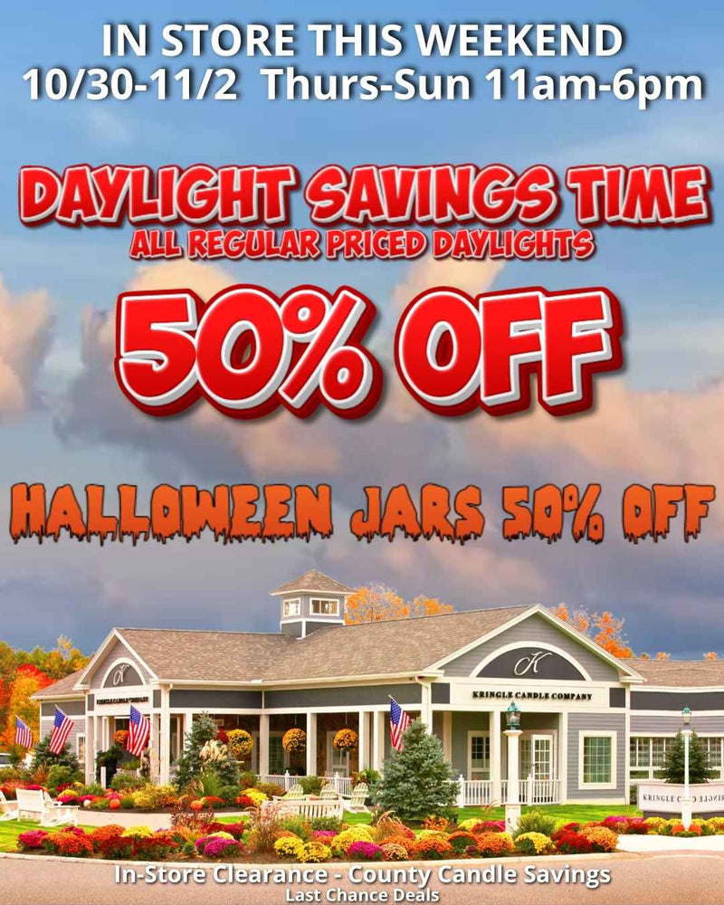 The Kringle Candle Flagship Store surrounded by colorful fall mums and foliage under a bright sky. Promotional text reads “In Store This Weekend 10/30–11/2, Thurs–Sun 11AM–6PM. Daylight Savings Time 50% Off All Regular Priced Daylights. Halloween Jars 50% Off.”