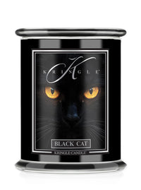 A black glass Halloween jar candle with a matching black lid, featuring a label with a black cat's face and glowing yellow eyes. The label reads 'KRINGLE' and 'BLACK CAT'.