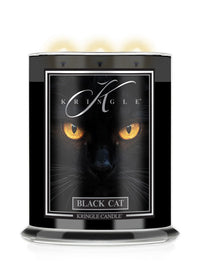 A Kringle Candle in a black Halloween jar featuring a graphic label of a black cat's face with glowing yellow eyes and the text 'BLACK CAT'.