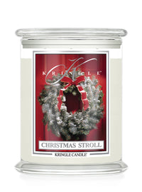 Christmas Stroll scented 3-wick candle by Kringle Candle with a red label and a holiday wreath on a door.