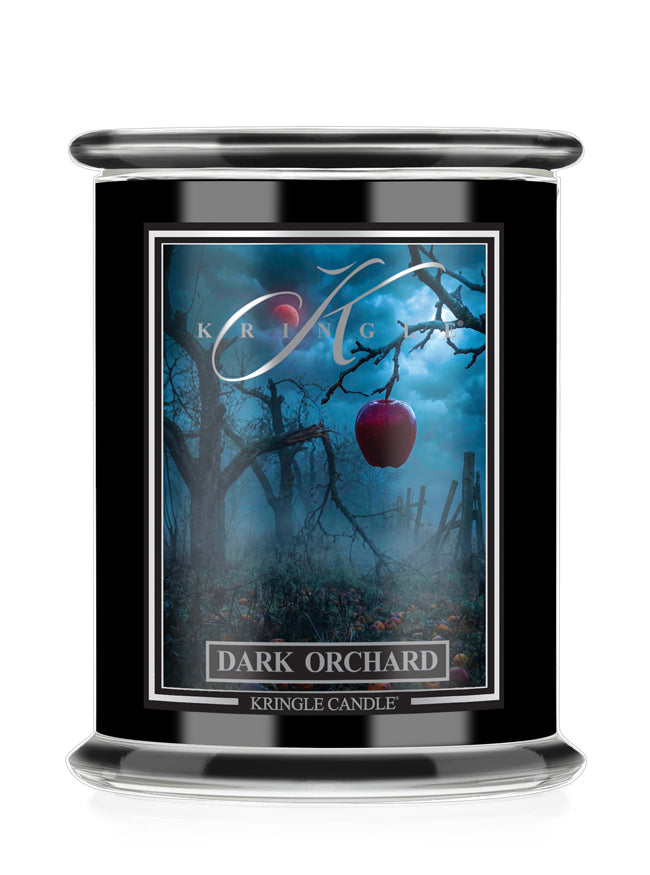 Kringle Candle's Halloween Dark Orchard Candle with an apple and leafless trees.