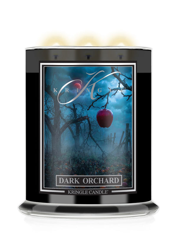 Kringle Candle's Halloween Dark Orchard Candle with an apple and leafless trees.