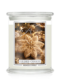 A Kringle Candle in a clear glass jar with a white wax fill and a decorative front label featuring a gilded cookie design and the scent name 'Gilded Cookie'.