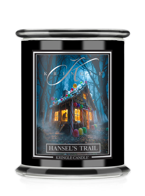 A black glass jar Halloween candle featuring a front label for 'Kringle Candle' titled 'Hansel's Trail'. The label shows a whimsical, glowing haunted house surrounded by colorful candy-like shapes in a dark blue forest.