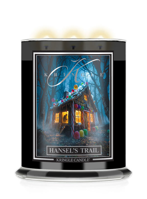 A large black glass jar Halloween candle with three lit wicks, featuring a front label titled 'Hansel's Trail' by Kringle Candle. The label shows a whimsical haunted house surrounded by bare trees at night, with glowing windows and colorful candy decorations.