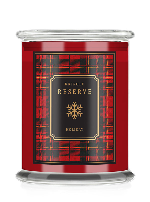 A red glass jar candle with a clear lid, featuring a red and black plaid label with gold text that reads 'KRINGLE RESERVE HOLIDAY' and a gold snowflake icon.