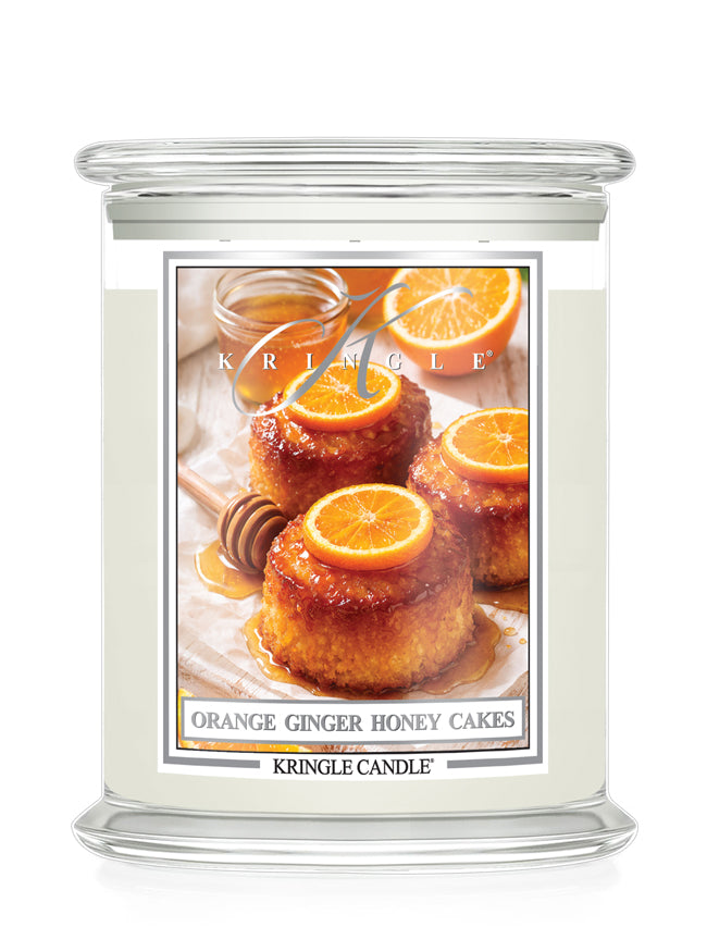 Kringle Candle with a label featuring Orange Ginger Honey Cakes on a white background