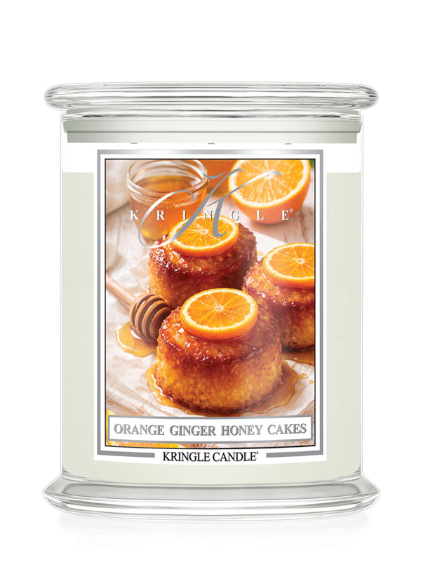 Kringle Candle with a label featuring Orange Ginger Honey Cakes on a white background