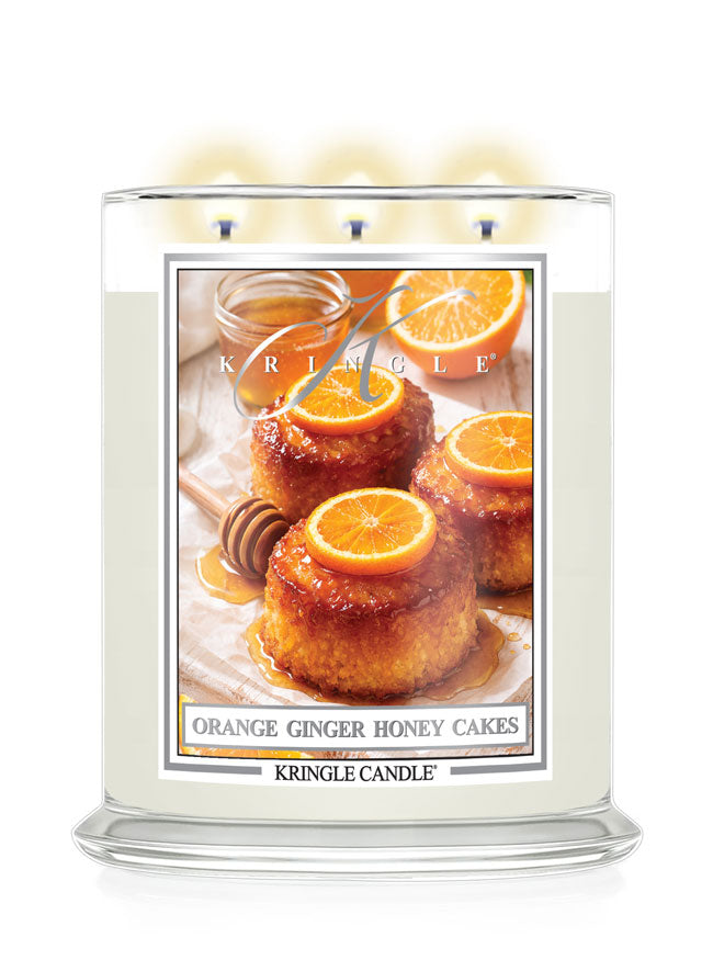 Kringle Candle with a label featuring Orange Ginger Honey Cakes on a white background