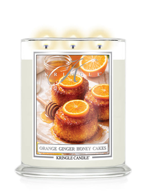 Kringle Candle with a label featuring Orange Ginger Honey Cakes on a white background